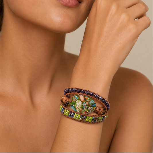 A close-up of a woman's wrist wearing a multi-strand beaded bracelet with colorful green, blue, and purple beads, brown wooden beads, and a central floral inlay.