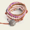 Stack of beaded bracelets with a decorative button clasp on a light background