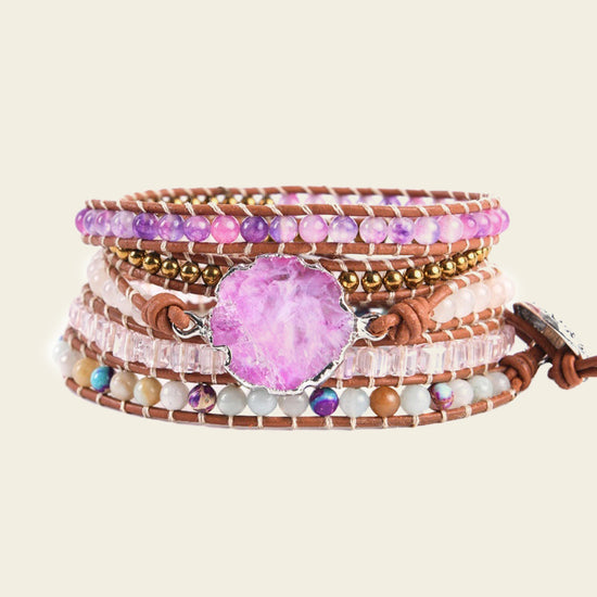 Multistrand bracelet with beads and a pink stone on a beige background