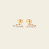 Gold earrings with clear stones on a beige background