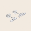 A pair of silver stud earrings with three marquise-cut clear crystals on each earring, displayed on a solid light beige background.