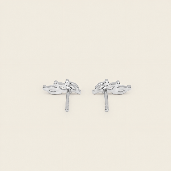 A pair of silver-toned stud earrings with a stylized leaf or vine motif, shown on a plain light beige background.