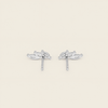 A pair of silver-toned stud earrings with a stylized leaf or vine motif, shown on a plain light beige background.