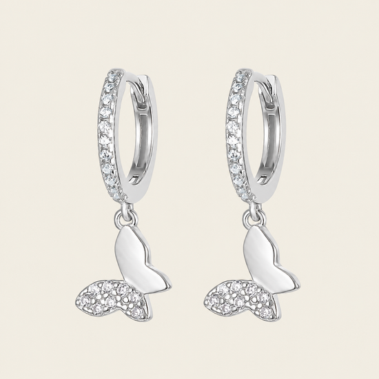 Silver hoop earrings with crescent moon designs on a light beige background