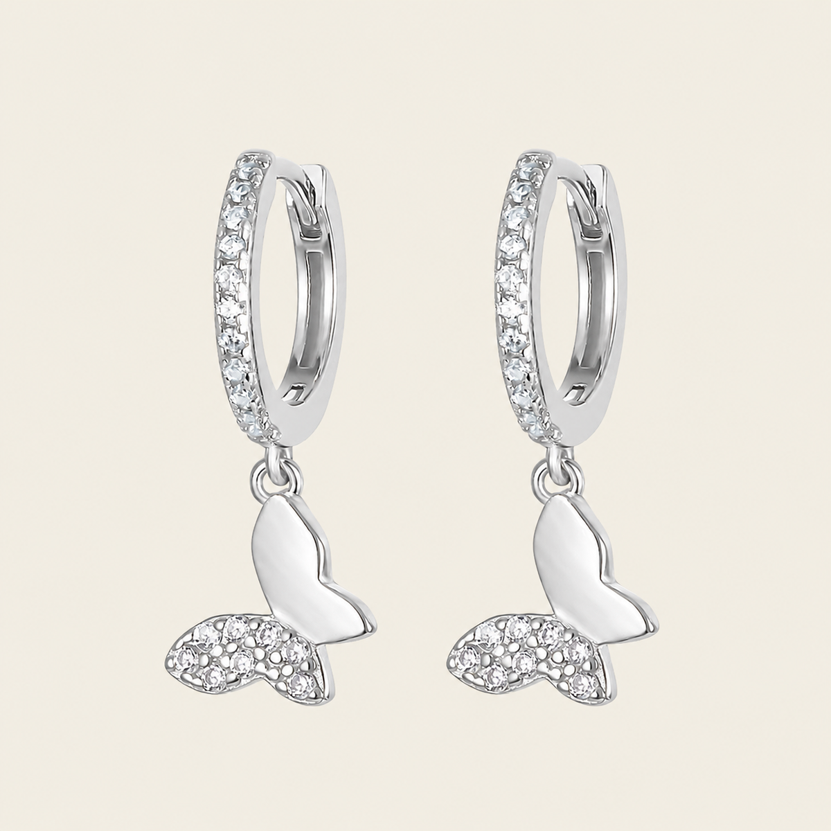 Silver hoop earrings with crescent moon designs on a light beige background