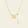 Gold butterfly necklace on a beige background