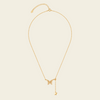Gold necklace with a butterfly pendant on a beige background