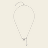 A delicate silver chain necklace featuring a small butterfly pendant and a dangling heart charm, displayed against a solid light beige background.