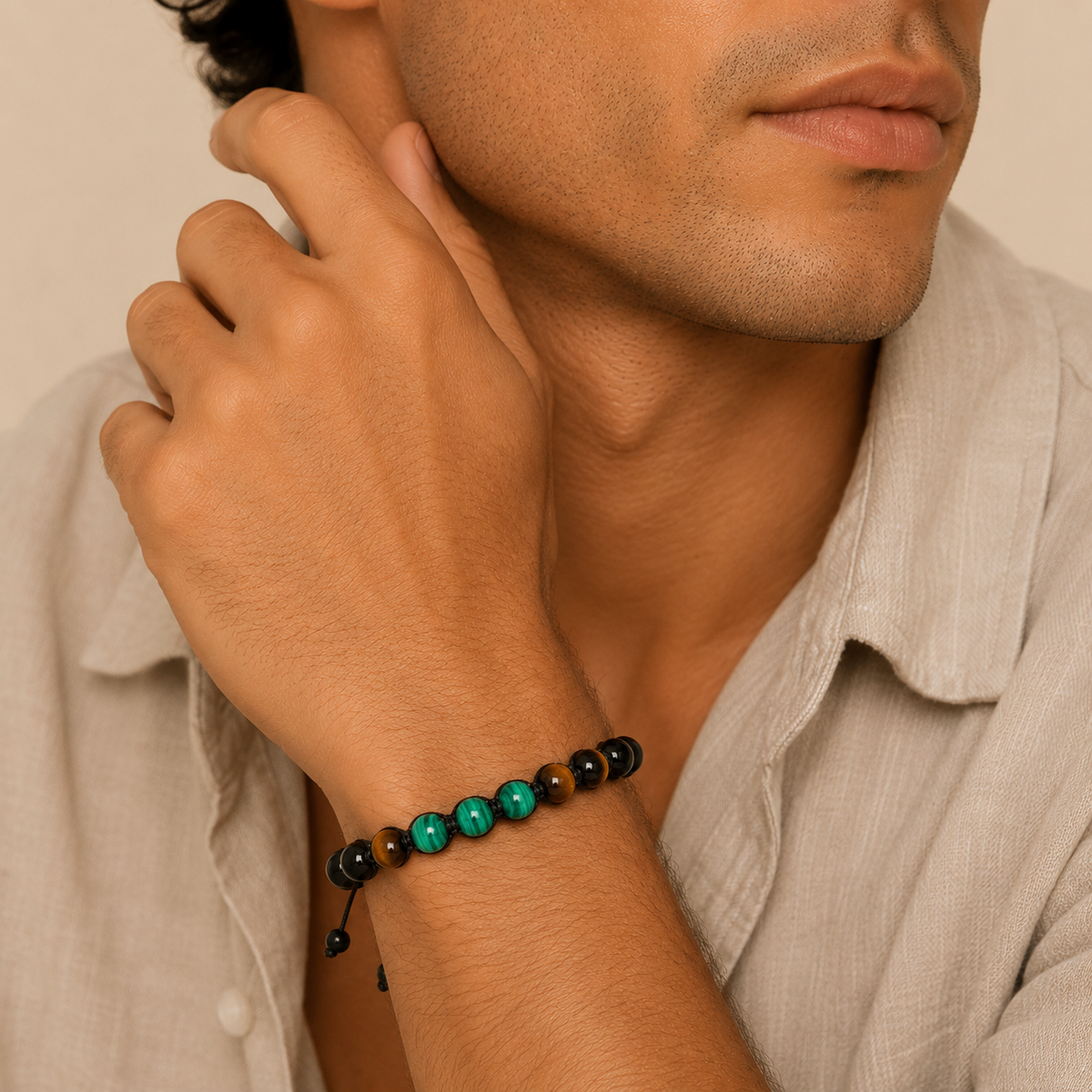 Man wearing a bracelet with beads on a neutral background