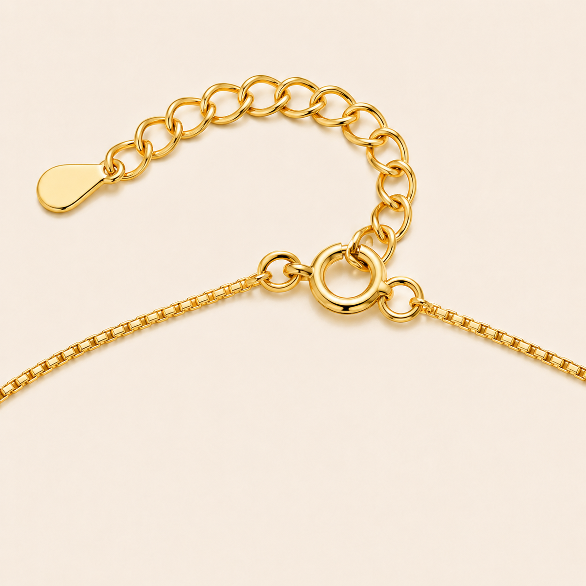 Gold chain clasp on a beige background