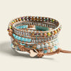 Stack of colorful beaded bracelets with metal accents on a beige background