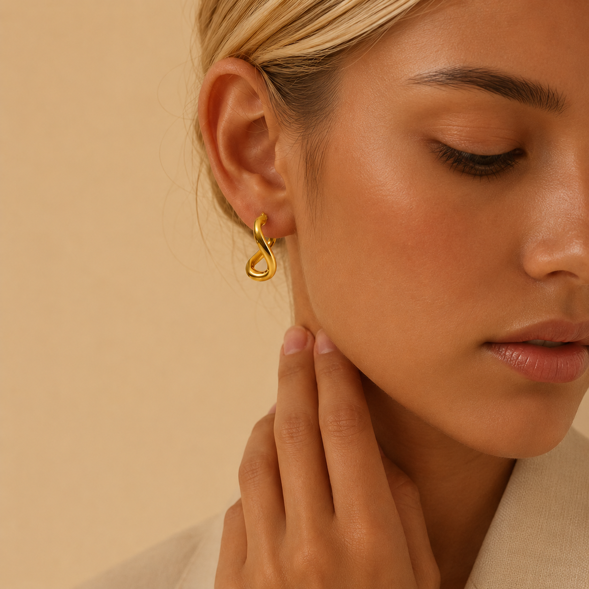 Close-up of a woman wearing a gold earring against a beige background