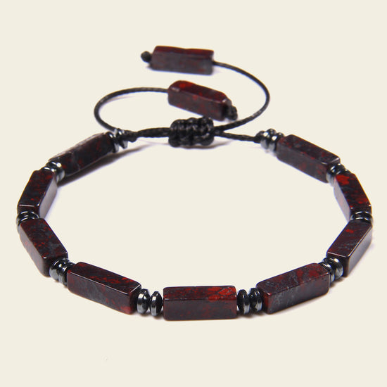 Bracelet with red and black beads on a beige background