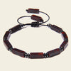 Bracelet with red and black beads on a beige background