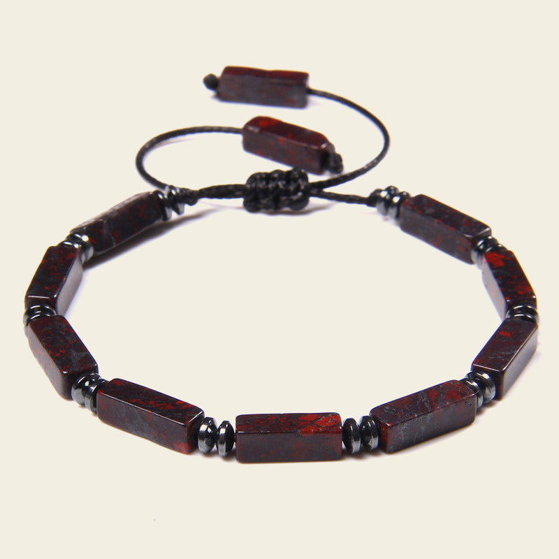Bracelet with red and black beads on a beige background