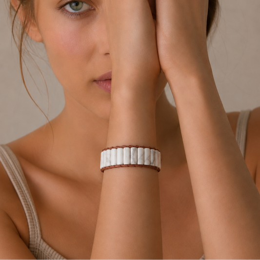 Woman wearing a white beaded bracelet on a neutral background
