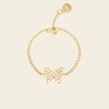 Gold butterfly bracelet on a beige background
