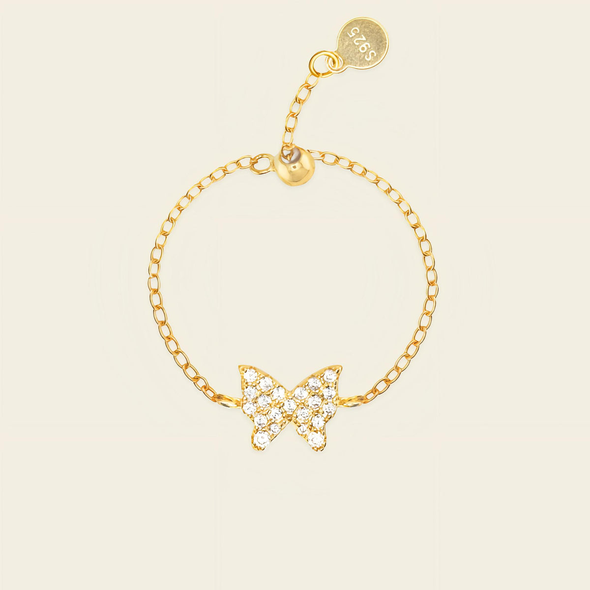 Gold butterfly bracelet on a beige background