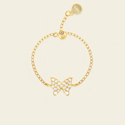 Gold butterfly bracelet on a beige background