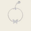 A silver chain bracelet featuring a butterfly-shaped charm paved with clear crystals, shown on a light beige background. The bracelet includes an adjustable lobster clasp with a round tag engraved with '925'.
