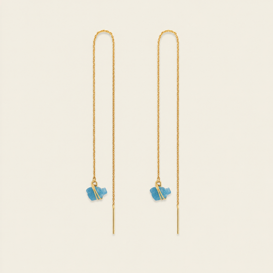 A pair of gold chain drop earrings with small blue stone charms, displayed on a light cream background.