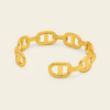A gold chain link bracelet with a distinctive interlocking double-O design, displayed on a light cream background.