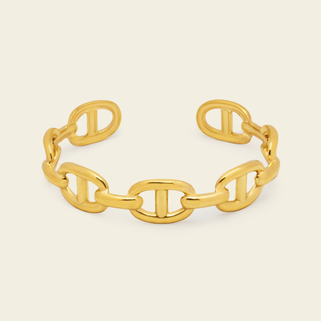 A polished gold chain-link cuff bracelet with interlocking oval links, shown on a clean off-white background.