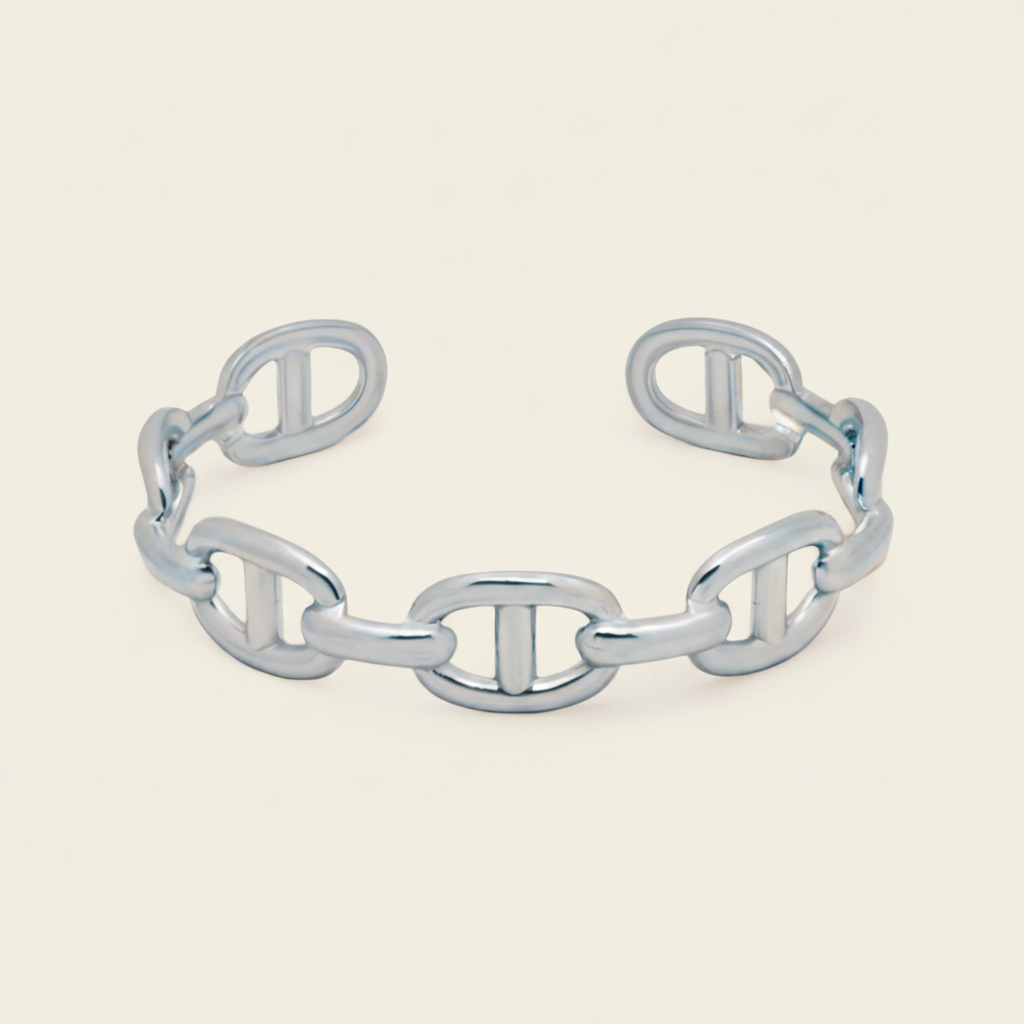 A polished chain-link cuff bracelet with interlocking oval links, shown on a clean off-white background.
