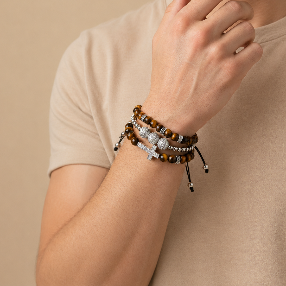 Person wearing multiple bracelets on a beige background