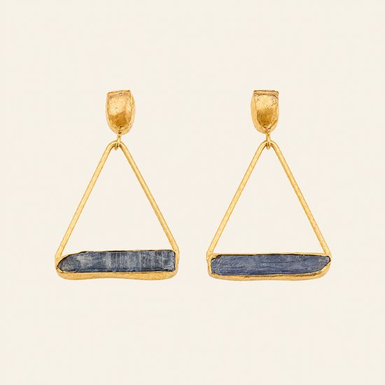 Gold triangle earrings with blue stone accents on a beige background