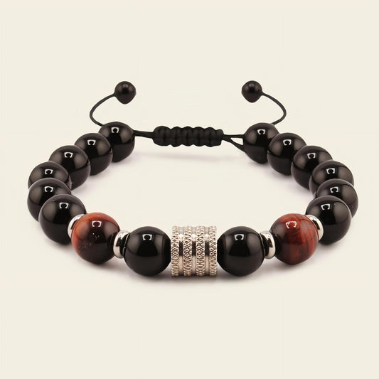 Black and brown beaded bracelet with a silver clasp on a beige background