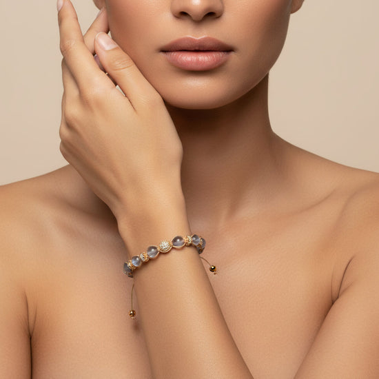 Woman wearing a delicate bracelet on a neutral background