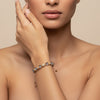 Woman wearing a delicate bracelet on a neutral background