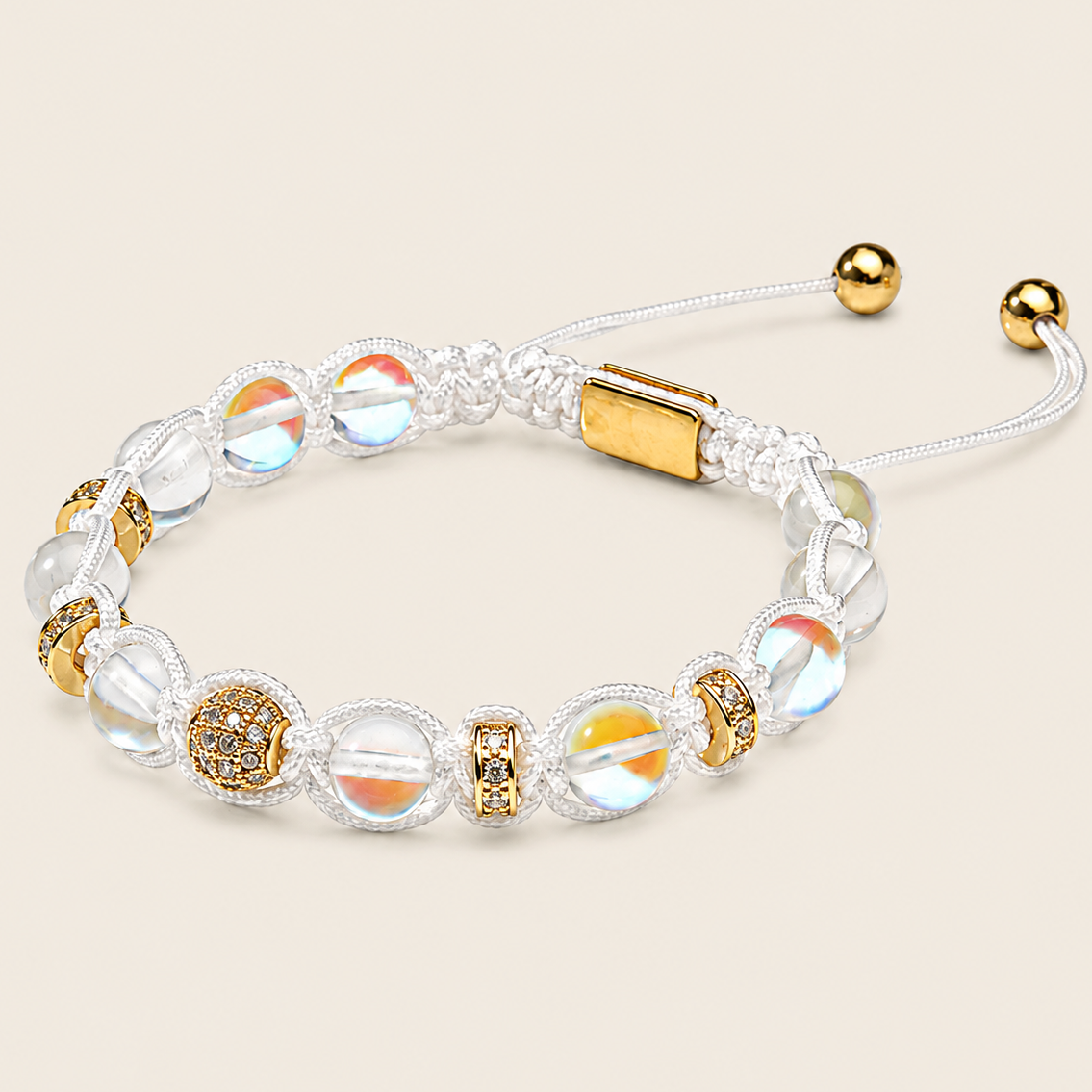 A beaded adjustable bracelet with clear round beads, iridescent beads, gold-toned spacer details, and a gold clasp on a white cord, shown on a light beige background.