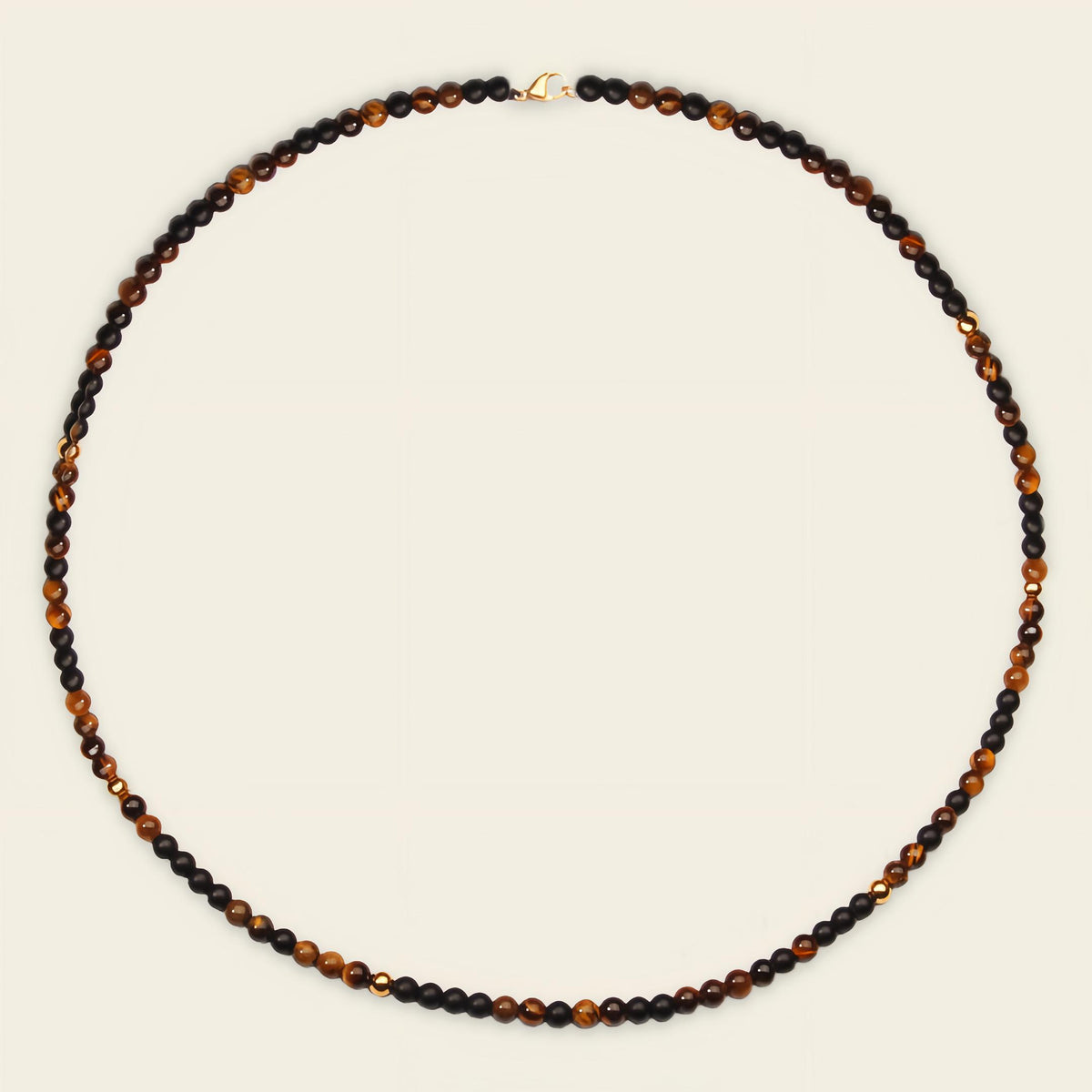 Necklace with black and brown beads on a beige background
