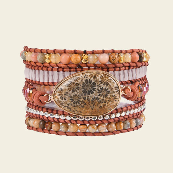 Multistrand bracelet with beads and a decorative clasp on a beige background