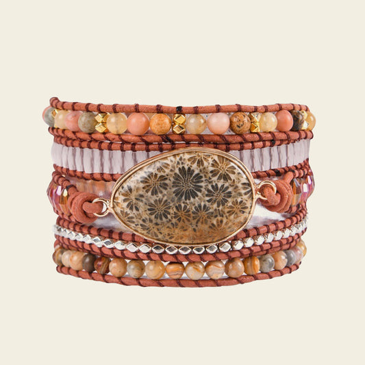 Multistrand bracelet with beads and a decorative clasp on a beige background