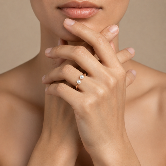Close-up of a hand wearing a pearl ring with a neutral background