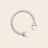 Silver ring with two pearls on a beige background