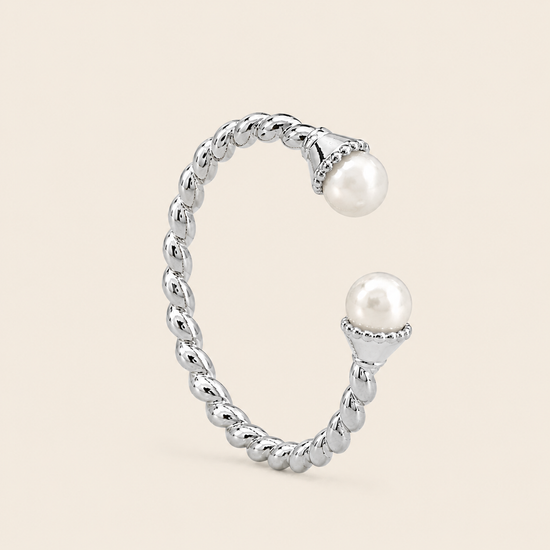 Silver ring with pearls on a beige background