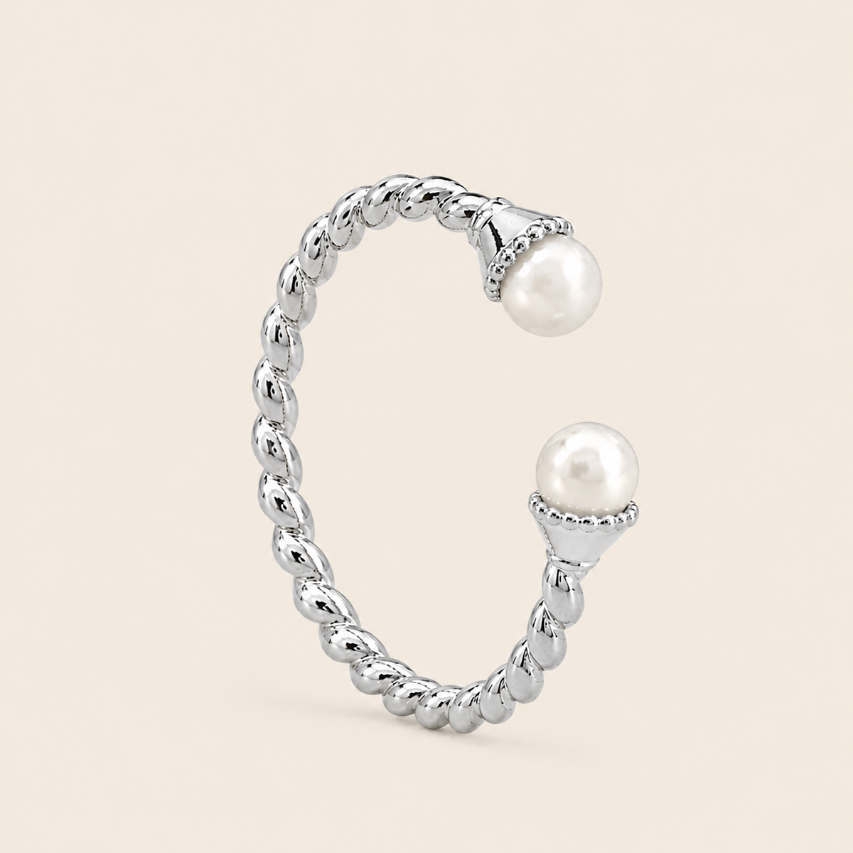 Silver ring with pearls on a beige background