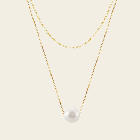 Two gold necklaces with a pearl pendant on a beige background