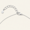 Close-up of a silver chain necklace showing an adjustable lobster clasp, extension chain with oval links, and a small teardrop tag stamped with '925' on a light cream background.