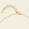 Close-up of a gold chain necklace showing an adjustable lobster clasp and a clasp on a light cream background.