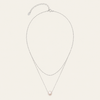 A delicate double-layered necklace featuring a silver-tone chain with an extender clasp and a single round, pale pink pearl pendant, displayed on a light cream background.