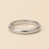 A polished silver band ring with a smooth, rounded profile, displayed on a solid light beige background.