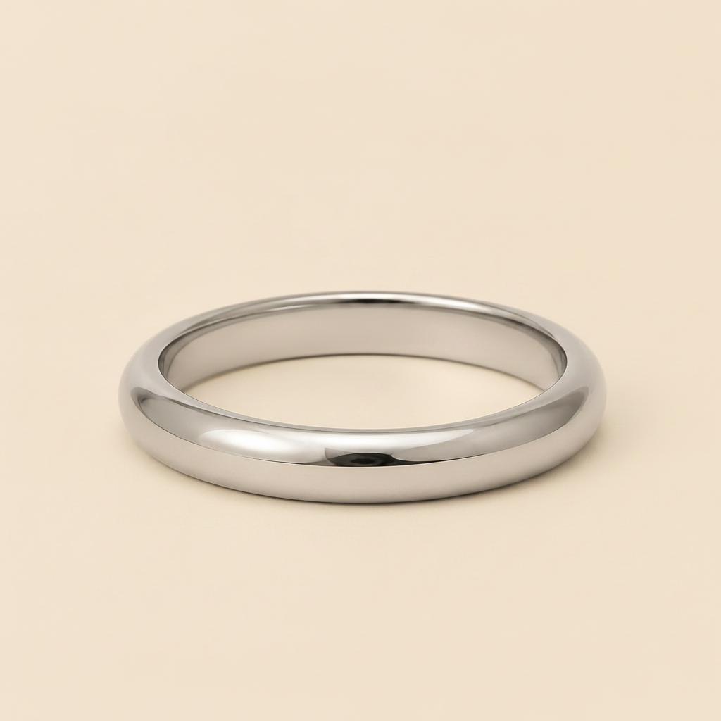 A polished silver band ring with a smooth, rounded profile, displayed on a solid light beige background.