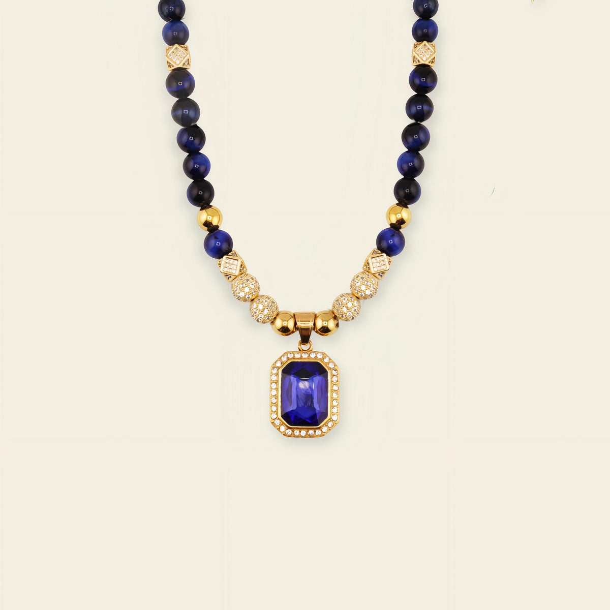 Necklace with blue beads and a gold pendant on a light background