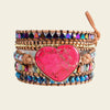 Multistrand bracelet with a pink heart-shaped stone on a beige background