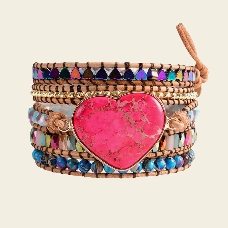Multistrand bracelet with a pink heart-shaped stone on a beige background